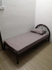 怡保Homey Hostel的一张位于房间角落的床