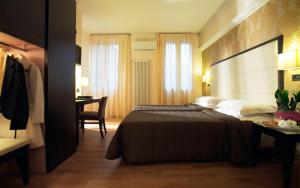 博洛尼亚旅游酒店的一间卧室配有一张床和一张书桌