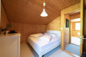 维尔德豪斯Schwendiblick的木制客房内的一间白色床卧室