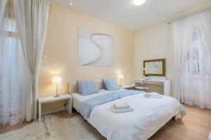 奥帕提亚罗纳奥帕蒂亚高级公寓的一间卧室设有一张大床和两个窗户。