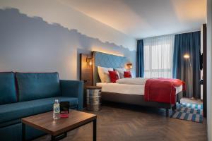 汉堡Holiday Inn - the niu, Keg Hamburg Ost, an IHG Hotel的酒店客房,配有床和沙发