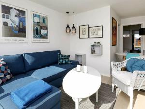 博恩瑟4 person holiday home in Bogense的客厅配有蓝色的沙发和白色的桌子