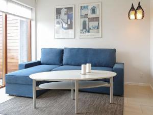 博恩瑟4 person holiday home in Bogense的客厅配有蓝色的沙发和桌子