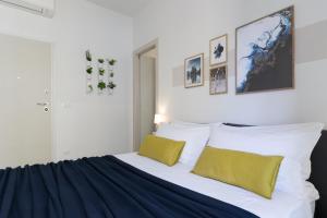 博洛尼亚Biasanòt Mini的一间卧室配有一张带黄色枕头的大床