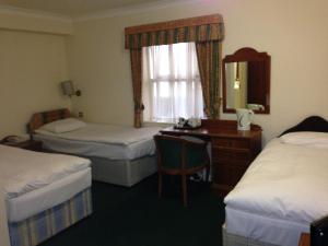 海维康修道院住宿酒店的酒店客房设有两张床、一张桌子和一面镜子