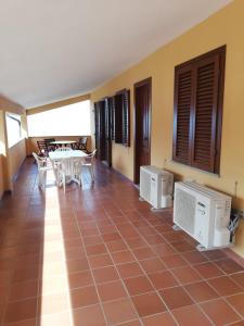 马尔恰纳Il Castagno的客房铺有瓷砖地板,配有桌椅。
