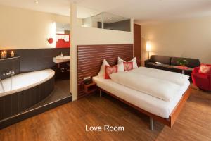 格林德尔瓦尔德海尔森酒店 - 格林德瓦的一间卧室配有一张床、一个浴缸和一张床,还设有一间浴室