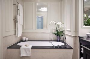 杜塞尔多夫Breidenbacher Hof, Best Grandhotel 2024 - Die 101 Besten的带浴缸和花瓶的浴室