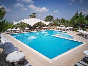 帕莫卡莱里士满帕马可瑟玛尔酒店的度假村的游泳池,配有椅子和遮阳伞