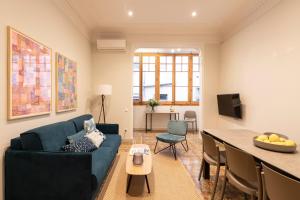 巴塞罗那Aspasios Gracia Apartments的客厅配有蓝色的沙发和桌子