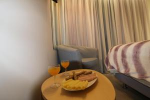 雅典Aiolos Apartments Ermou 64 4th Floor的一张桌子,上面放着一盘食物和两杯葡萄酒