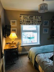 斯卡伯勒Waterfront Apartment的一间卧室配有一张床、一张书桌和一个窗户。