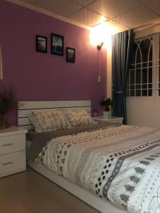 大叻Du Miên House的一间卧室设有两张床和紫色墙壁