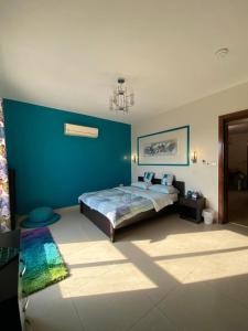 半月湾Majestic_vip的一间卧室设有一张床和蓝色的墙壁