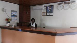 AdjumaniZawadi Hotel的坐在候诊室柜台上的女人
