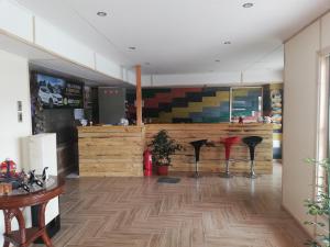纳塔列斯港Hostal Baquedano的餐厅铺有木地板,设有带凳子的柜台