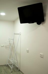 Kose-UuemõisaOXCafe Hostel的挂在白色墙壁上的平面电视