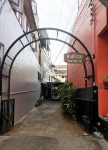 清迈Baan Nai Soi Mini Hotel的两栋建筑之间有拱门的小巷