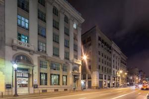 巴塞罗那EXE莱塔纳皇宫酒店的一条城市街道,晚上有两栋高大的建筑