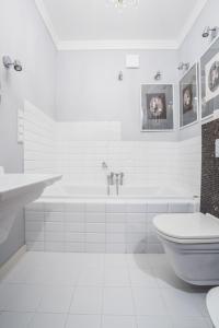 华沙Saskasummer的白色的浴室设有浴缸和卫生间。