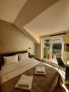 贝尔格莱德Urban Lodge Belgrade的一间卧室配有一张大床和两条毛巾