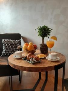 贝尔格莱德Urban Lodge Belgrade的一张木桌,上面放着水果和咖啡杯
