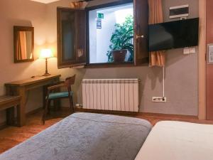 利维亚美茨芳达酒店的一间卧室配有一张床、一张书桌和一个窗户。