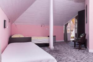 鲍洛通凯赖斯图尔Familia Apartman 304的卧室设有粉红色的墙壁、一张床和椅子