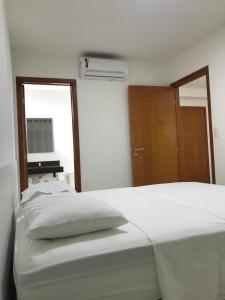 马塞约Apartamento Completo Jatiúca的卧室配有一张白色大床和木门