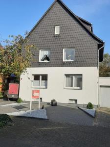 奥伯豪森Ferienwohnung Lorenz的前面有标志的白色房子