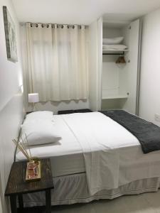 马塞约Apartamento Completo Jatiúca的卧室配有一张白色的大床和一张桌子