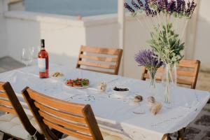 莫诺波利Casa della Madia的一张带鲜花的白色桌子和一瓶葡萄酒
