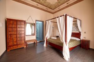 巴勒莫中心露台旅馆的一间卧室配有天蓬床和镜子