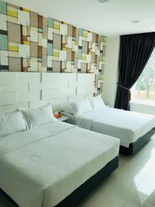 新山GOODY HOTEL的酒店客房设有两张床和窗户。