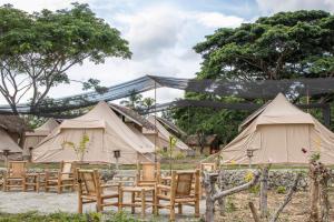 CarmenThe Acacia Glamping Park的一组桌椅位于帐篷前