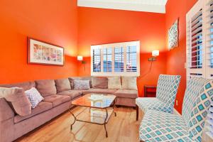 圣克鲁兹Boardwalk Dream的客厅拥有橙色的墙壁,配有沙发和椅子