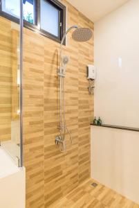 奥南海滩Aonang Eco Villa - SHA Extra Plus的带淋浴的浴室(带木墙)