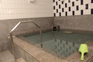 札幌札幌法华俱乐部酒店的浴室设有玻璃地板和浴缸