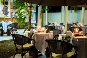 桑给巴尔Antonio Garden Hotel的餐厅配有桌椅和白色桌布