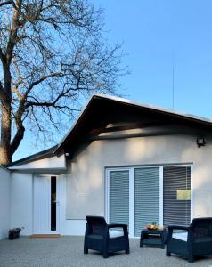 斯科林特普利采Grand Spa Holiday Home II的前面有两把椅子的白色房子
