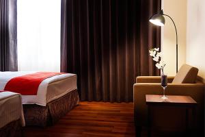 高雄高雄富野渡假酒店的酒店的客房 - 带一张床、椅子和窗户