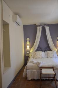 圣吉米纳诺安娜尼多二号招待所的一间卧室配有一张紫色墙壁的床