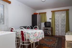鲍洛通费尼韦什Familia Nyaraló 87的客厅配有桌椅和电视。