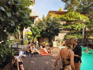 曼谷曼谷之游旅舍的一群人坐在游泳池周围