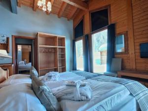 利维尼奥La Tresenda Hotel and Mountain Farm的木制客房内的一间卧室配有一张大床