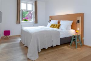 丁克尔斯比尔hezelhof hotel的卧室配有一张白色大床和木制床头板