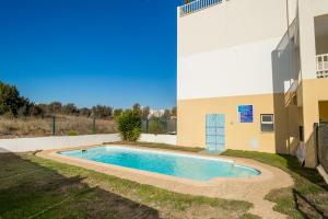 波尔蒂芒Apartamentos Castelos da Rocha的一座游泳池,位于一座建筑旁的院子内