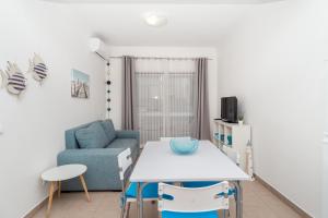 波尔蒂芒Apartamentos Castelos da Rocha的客厅配有桌子和蓝色沙发