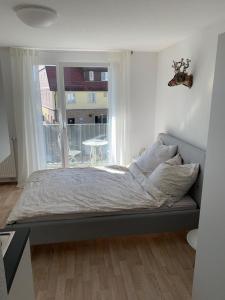 莱因费尔登-埃希特尔丁根1-Zi. Apartment, Echterdingen bei Flughafen/Messe Stgt.的卧室内的一张床铺,设有大窗户