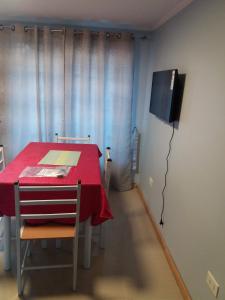 维库尼亚Cabañas Rivadavia Spa的一间带红色桌子和电视的用餐室